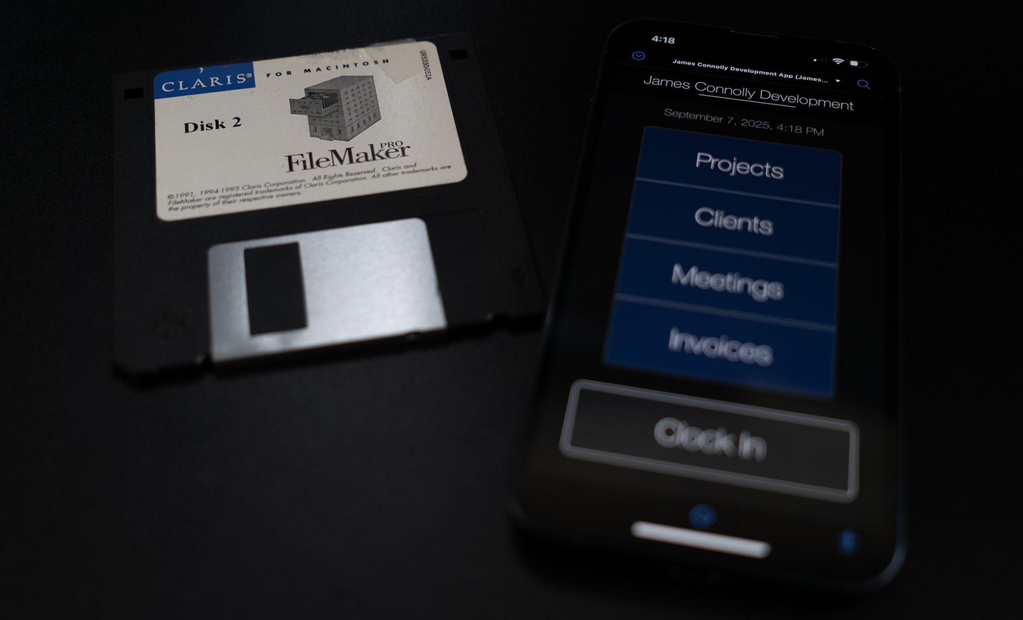 Claris FileMaker floppy disk from the 1990s beside a smart phone with a contemporary Claris app.